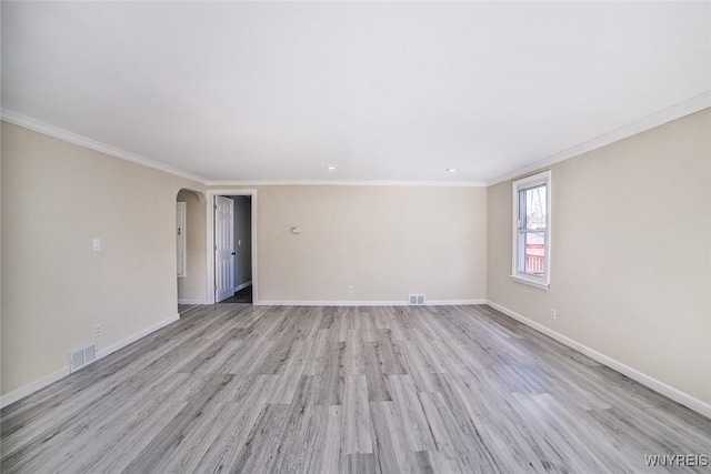 unfurnished room featuring light wood finished floors, baseboards, visible vents, and arched walkways