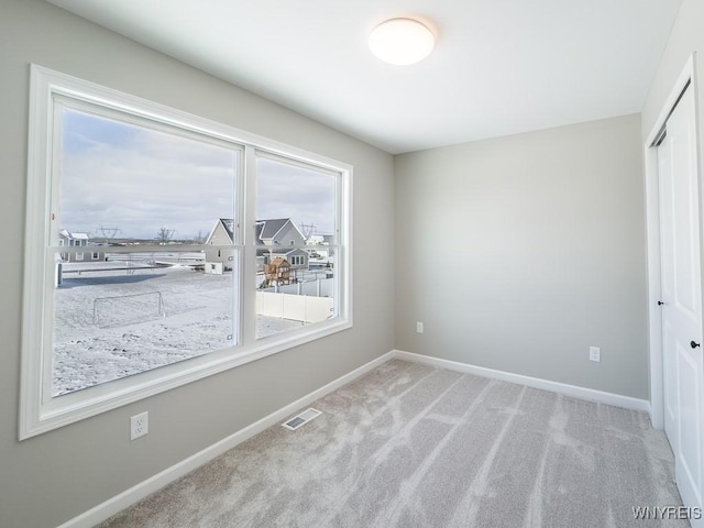 unfurnished bedroom with light carpet and a closet