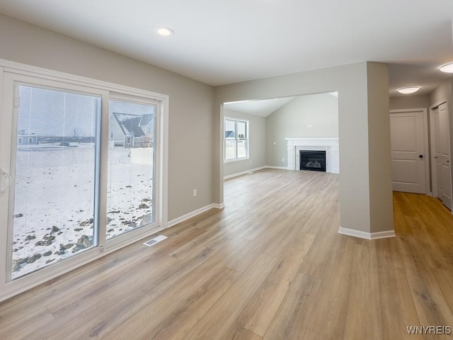 unfurnished living room with vaulted ceiling and light hardwood / wood-style floors