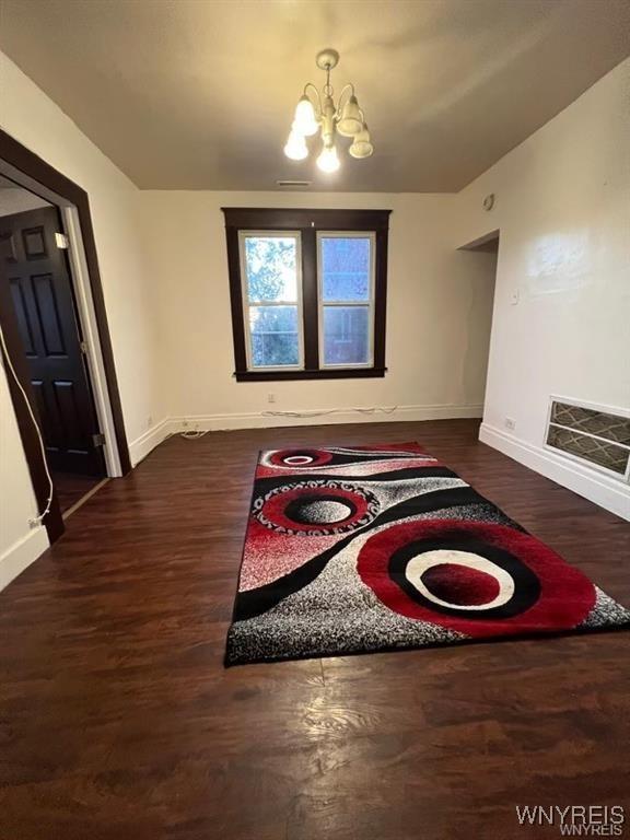 unfurnished dining area featuring dark hardwood / wood-style flooring and an inviting chandelier