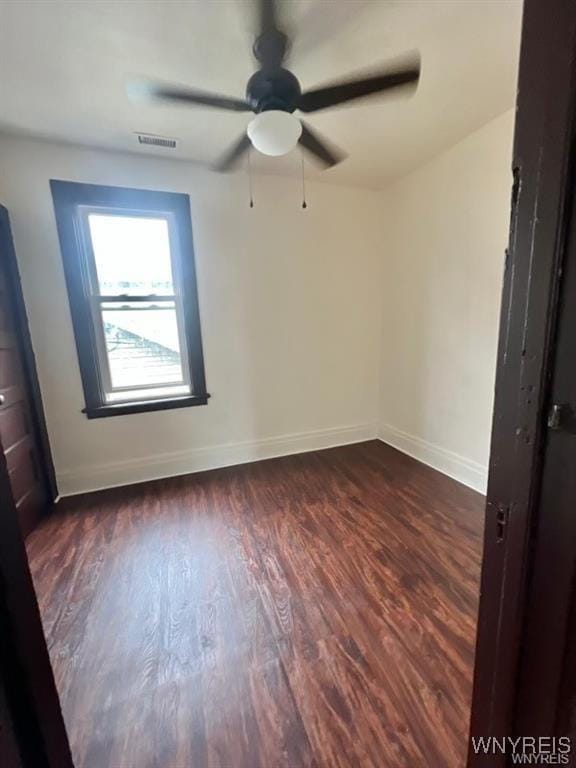 spare room with dark hardwood / wood-style floors and ceiling fan