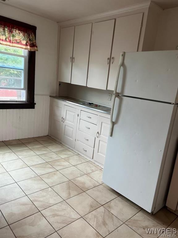 kitchen featuring white cabinets and white fridge