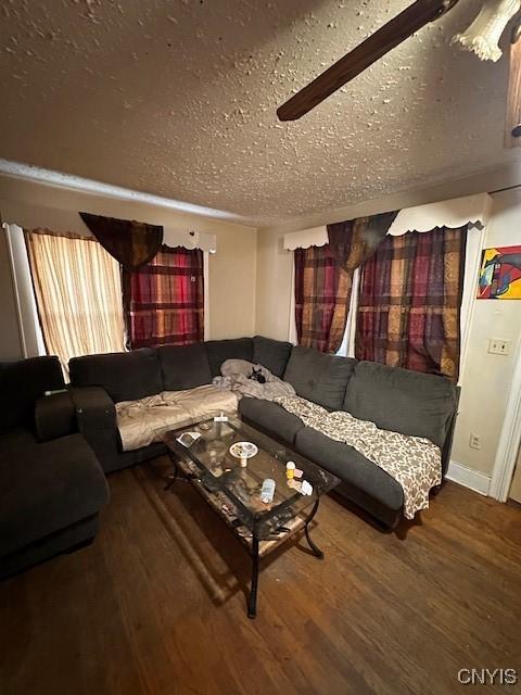 living room featuring ceiling fan, wood-type flooring, and a textured ceiling