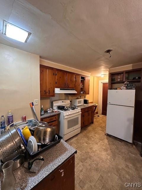 kitchen with dark countertops, white appliances, and under cabinet range hood