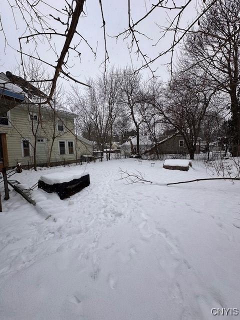 yard layered in snow featuring a garage