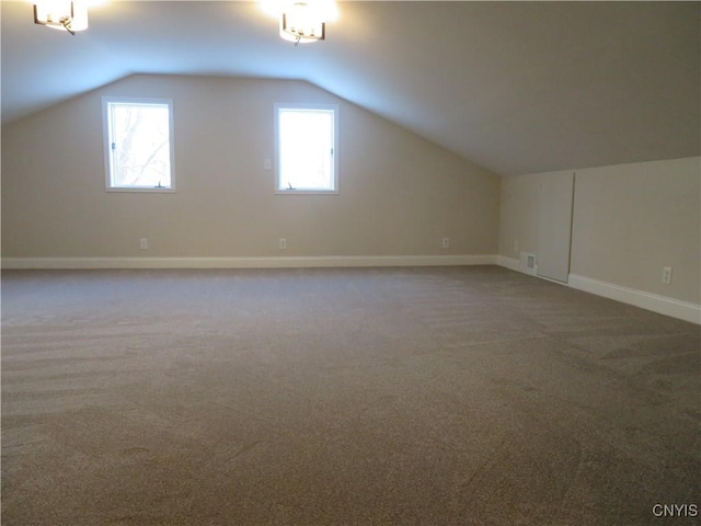 bonus room featuring plenty of natural light, carpet floors, and vaulted ceiling