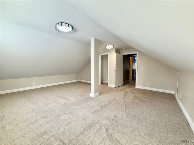 bonus room featuring light colored carpet and vaulted ceiling