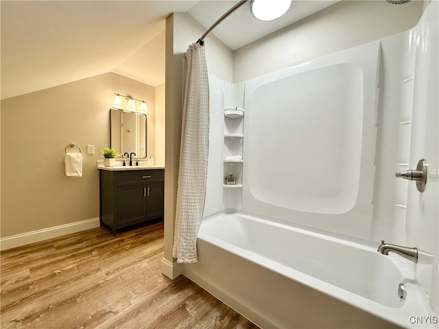 bathroom with hardwood / wood-style floors, vanity, shower / tub combo with curtain, and lofted ceiling