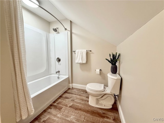 bathroom with hardwood / wood-style floors, toilet, lofted ceiling, and shower / bathtub combination with curtain