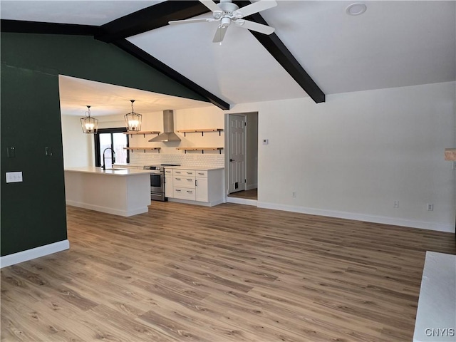 unfurnished living room with sink, ceiling fan with notable chandelier, light hardwood / wood-style flooring, and vaulted ceiling with beams