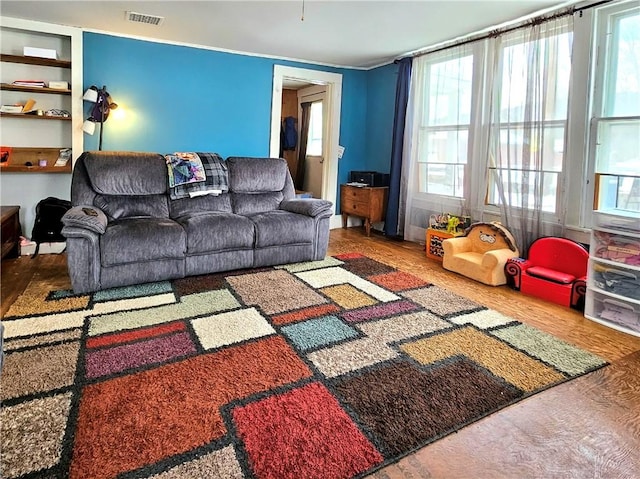 living room featuring built in features and wood-type flooring