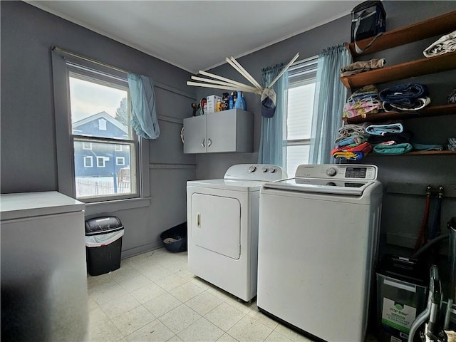 washroom with washer and clothes dryer and cabinets