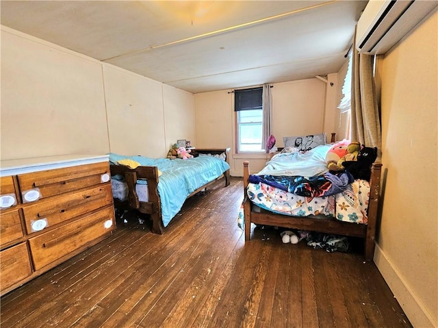 bedroom with dark wood-type flooring and a wall unit AC