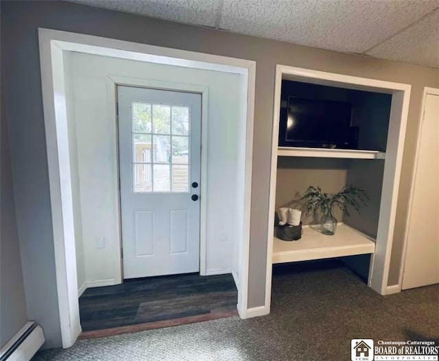 doorway with a paneled ceiling and baseboard heating