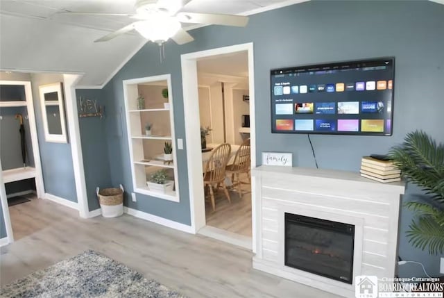 living room with ceiling fan, wood-type flooring, and lofted ceiling