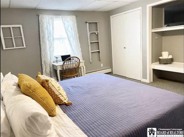 bedroom with carpet flooring, a drop ceiling, and a baseboard radiator