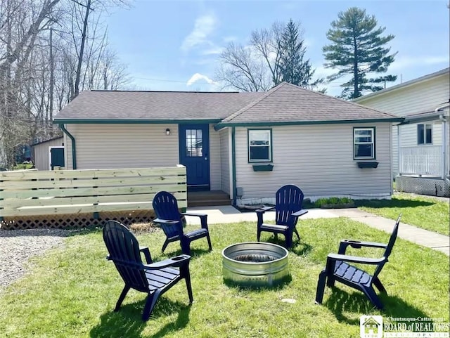 back of house featuring a yard and a fire pit