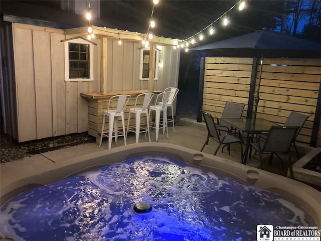 view of patio with a bar and a hot tub