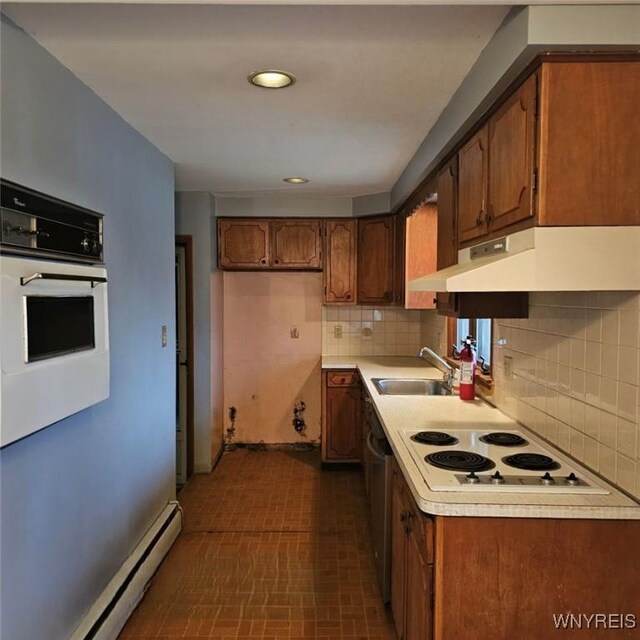 kitchen with white appliances, a baseboard radiator, backsplash, and sink