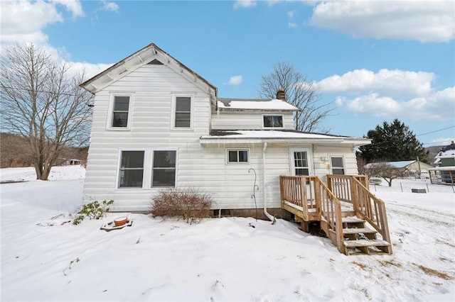 view of snow covered back of property