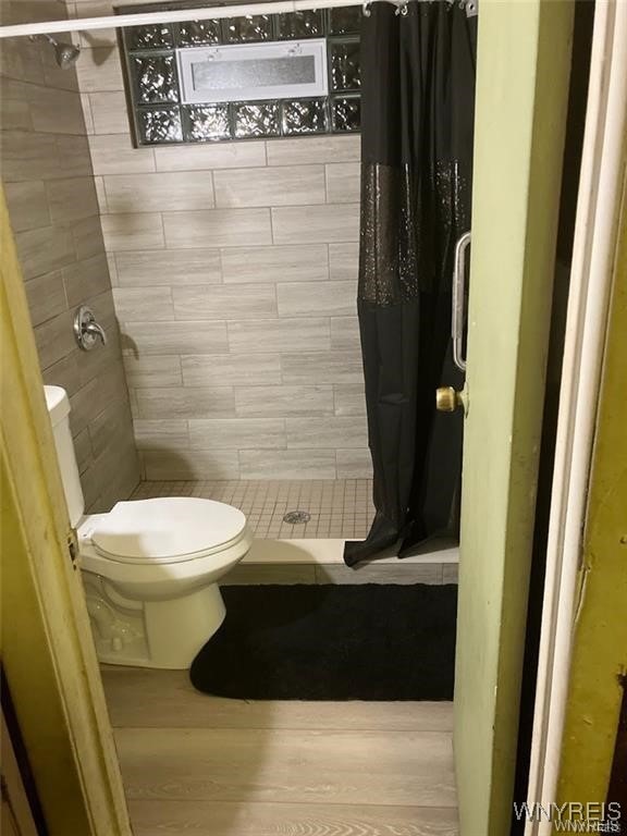 bathroom with toilet and curtained shower