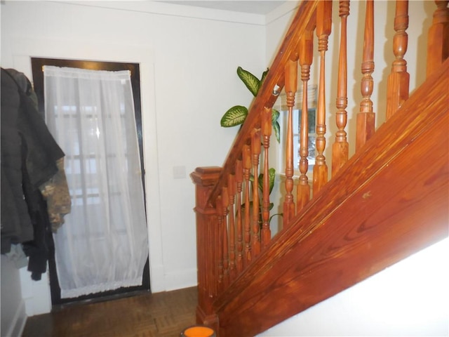 staircase featuring parquet floors