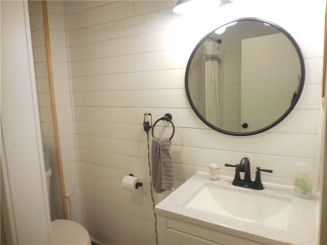 bathroom featuring vanity and wooden walls