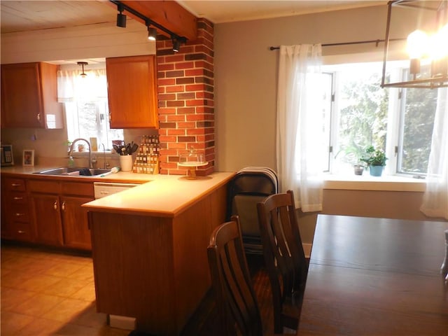 kitchen with backsplash, kitchen peninsula, sink, and track lighting