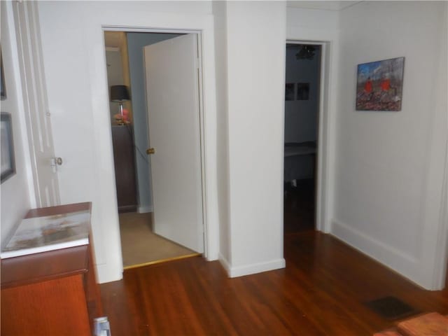 hallway with dark hardwood / wood-style flooring