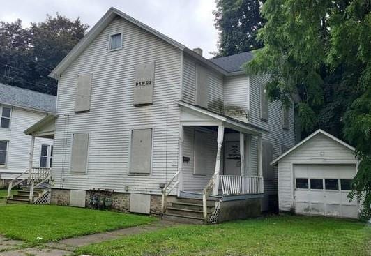 view of front of home featuring a garage, an outdoor structure, and a front lawn