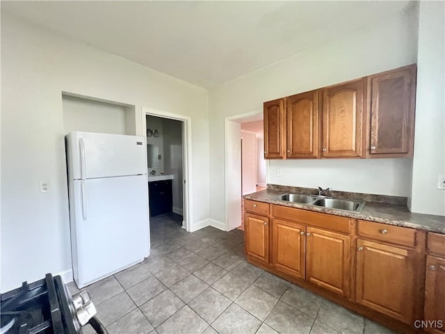 kitchen featuring sink, white fridge, and light tile patterned flooring