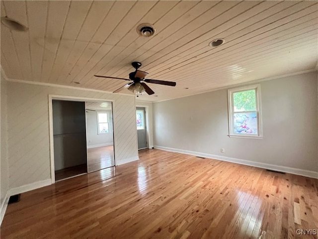 unfurnished bedroom featuring ceiling fan, wood-type flooring, ornamental molding, and a closet