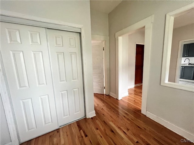 unfurnished bedroom with a closet, wood-type flooring, and sink