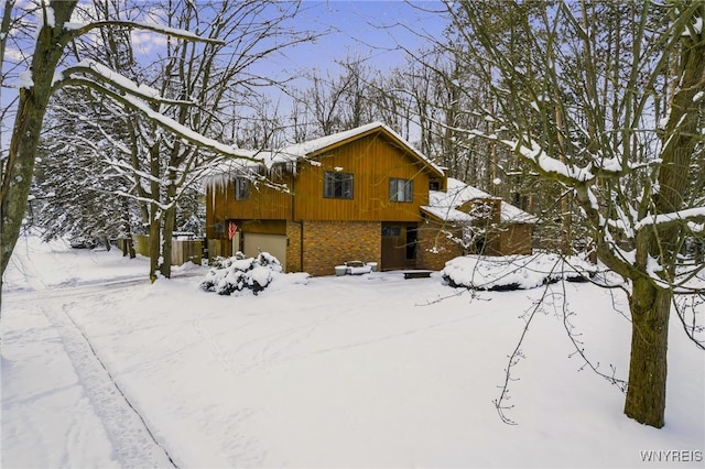 view of snowy exterior with a garage