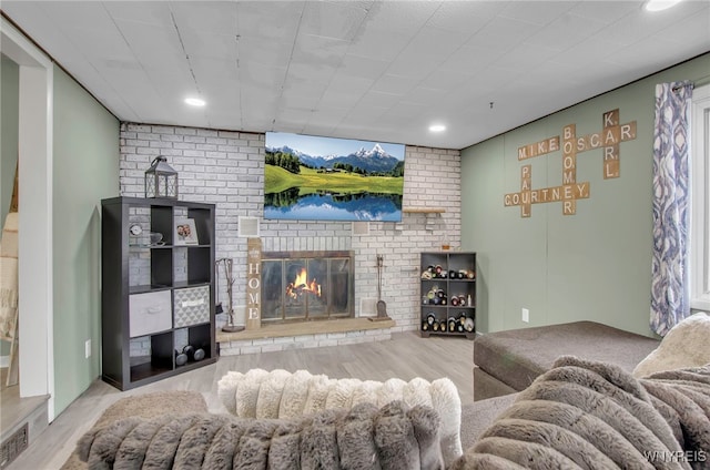 living room with light hardwood / wood-style flooring and a brick fireplace