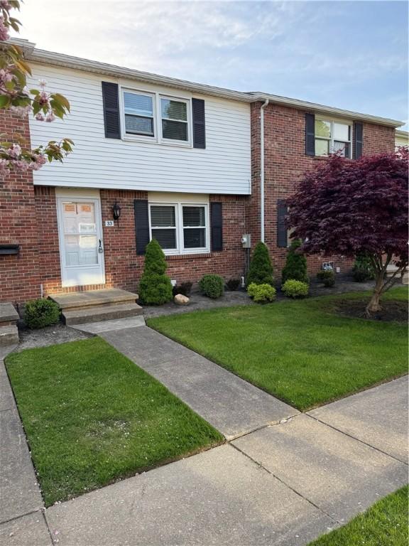 view of front of house with a front lawn and brick siding