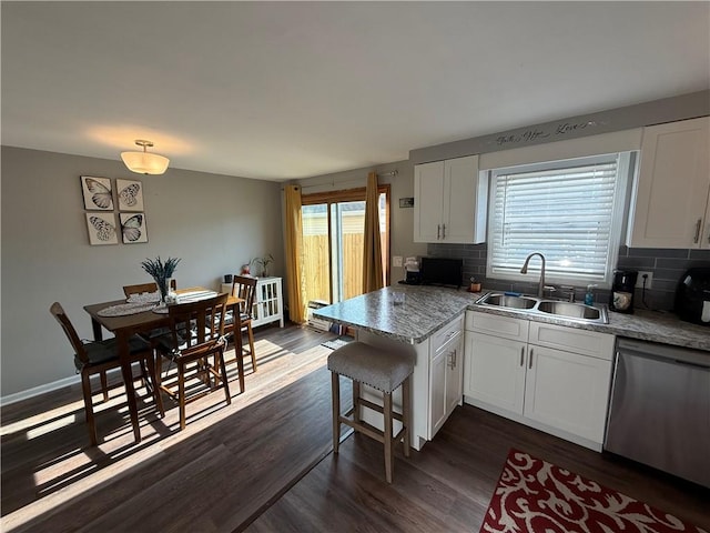 kitchen with a sink, dishwasher, dark wood-style floors, backsplash, and white cabinets