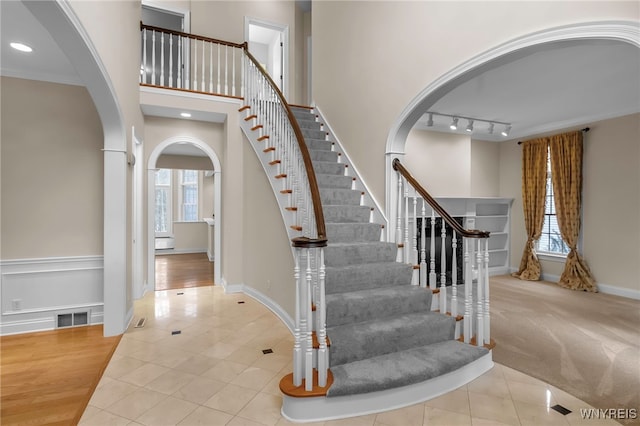 staircase featuring tile patterned floors and crown molding