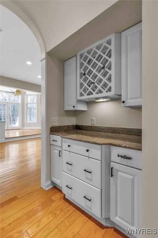 kitchen featuring white cabinetry, ceiling fan, and light wood-type flooring