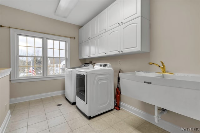 washroom featuring washer and clothes dryer, light tile patterned flooring, and cabinets