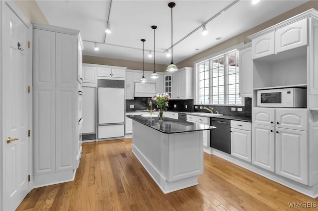 kitchen with white cabinets, a kitchen island, and white appliances