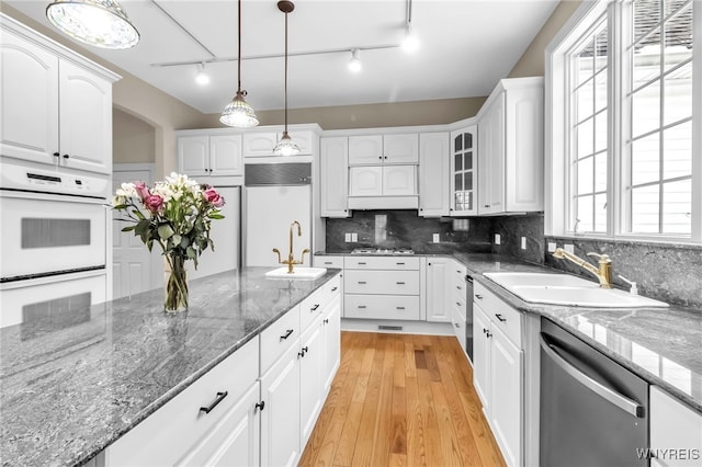 kitchen featuring sink, white cabinets, pendant lighting, and appliances with stainless steel finishes