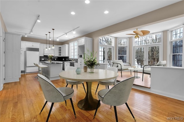 dining room with ceiling fan, light wood-type flooring, sink, and french doors