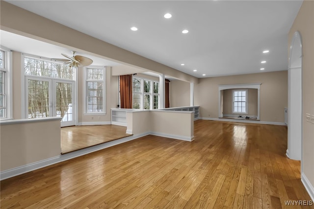 kitchen with a kitchen bar, ceiling fan, and light wood-type flooring