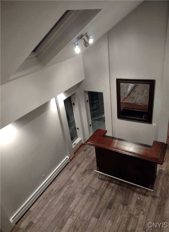 corridor with hardwood / wood-style floors and a baseboard radiator