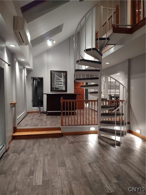 interior space featuring wood-type flooring, a baseboard radiator, and a wall mounted air conditioner