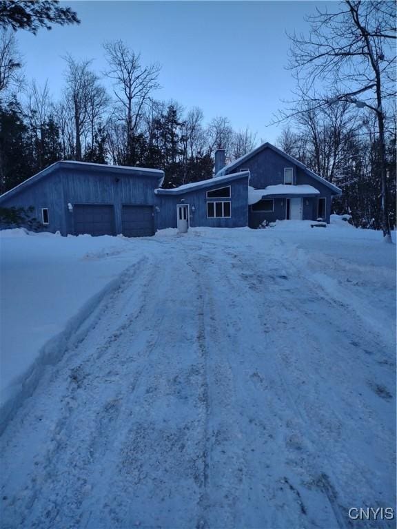 snow covered property featuring a garage