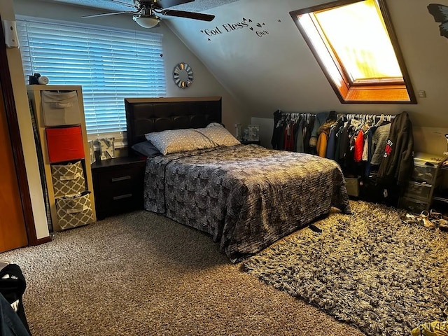 carpeted bedroom with ceiling fan and vaulted ceiling with skylight