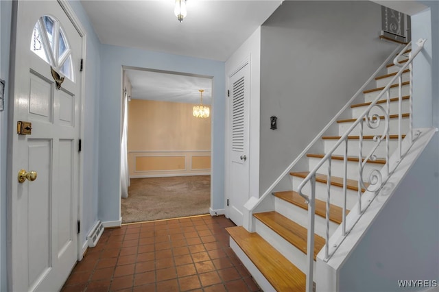 carpeted foyer featuring a chandelier