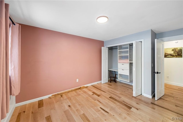 unfurnished bedroom with a closet and light hardwood / wood-style flooring